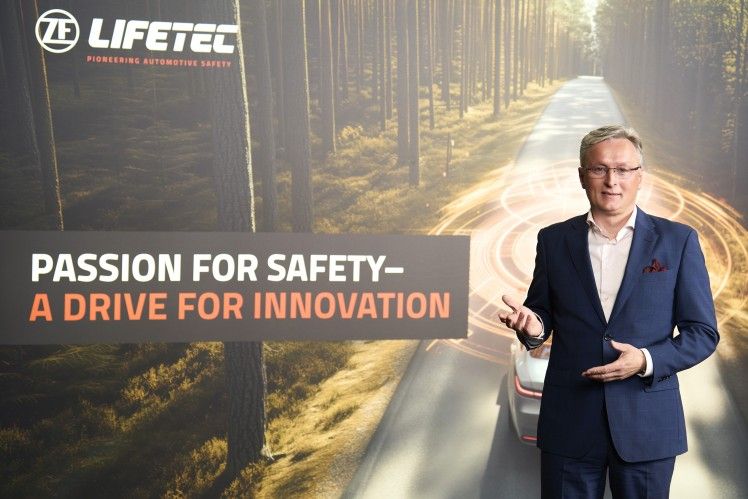 Mann in Anzug vor Waldstraße, ZF Lifetec Logo, Passion for Safety