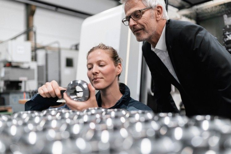 Mitarbeiterin zeigt ZF-Lifetec-Technik einem älteren Kollegen in der Fabrik