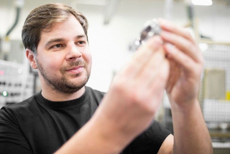 Mann hält Autoteil in Fabrik