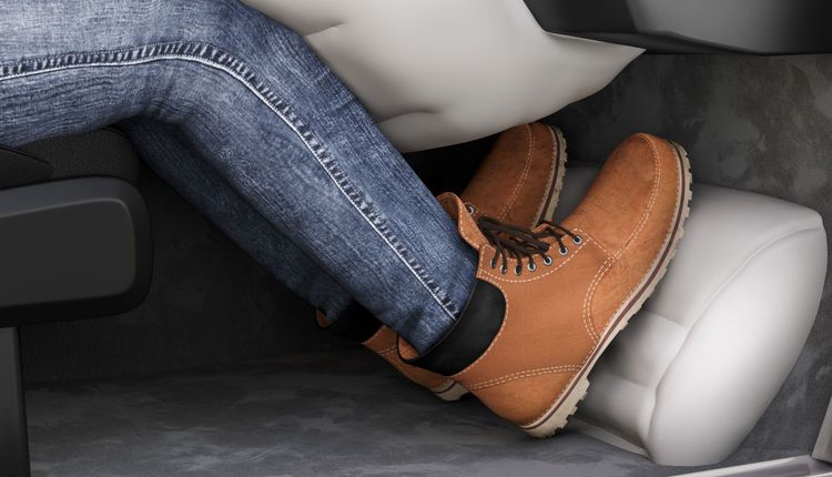 Person mit Jeans und Stiefeln auf Autobremsen