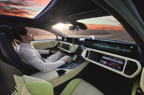 Mann sitzt in einem modernen Auto mit digitalem Armaturenbrett