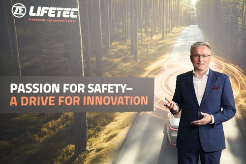 Mann in Anzug vor Waldstraße, ZF Lifetec Logo, Text: Leidenschaft für Sicherheit – Eine Fahrt für Innovation